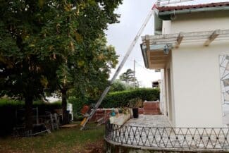 Échelle télescopique installée dans le jardin pour accéder à la toiture