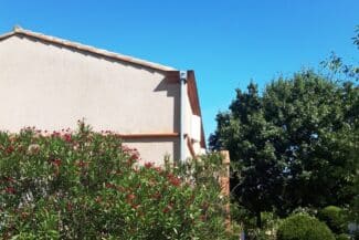 Maison et toiture vues depuis le jardin après entretien