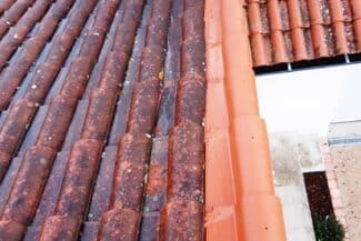 Toiture ancienne aux tuiles encrassées le long d'une descente