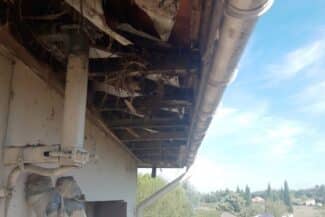 Planche de rive en bois dégradée sous le débord de toit à Colomiers