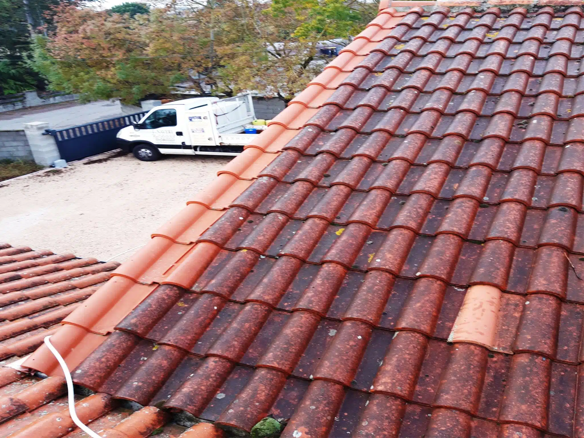 Toiture nettoyée vue depuis la cour, véhicule de chantier au fond