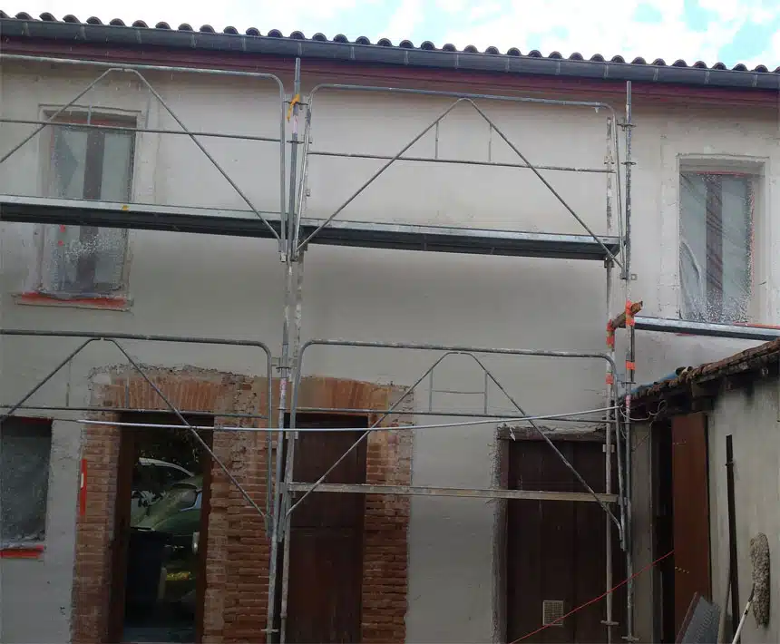 Façade sous échafaudage avec ouvertures en briques