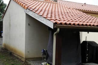 Auvent et façade claire d'une maison individuelle entretenue