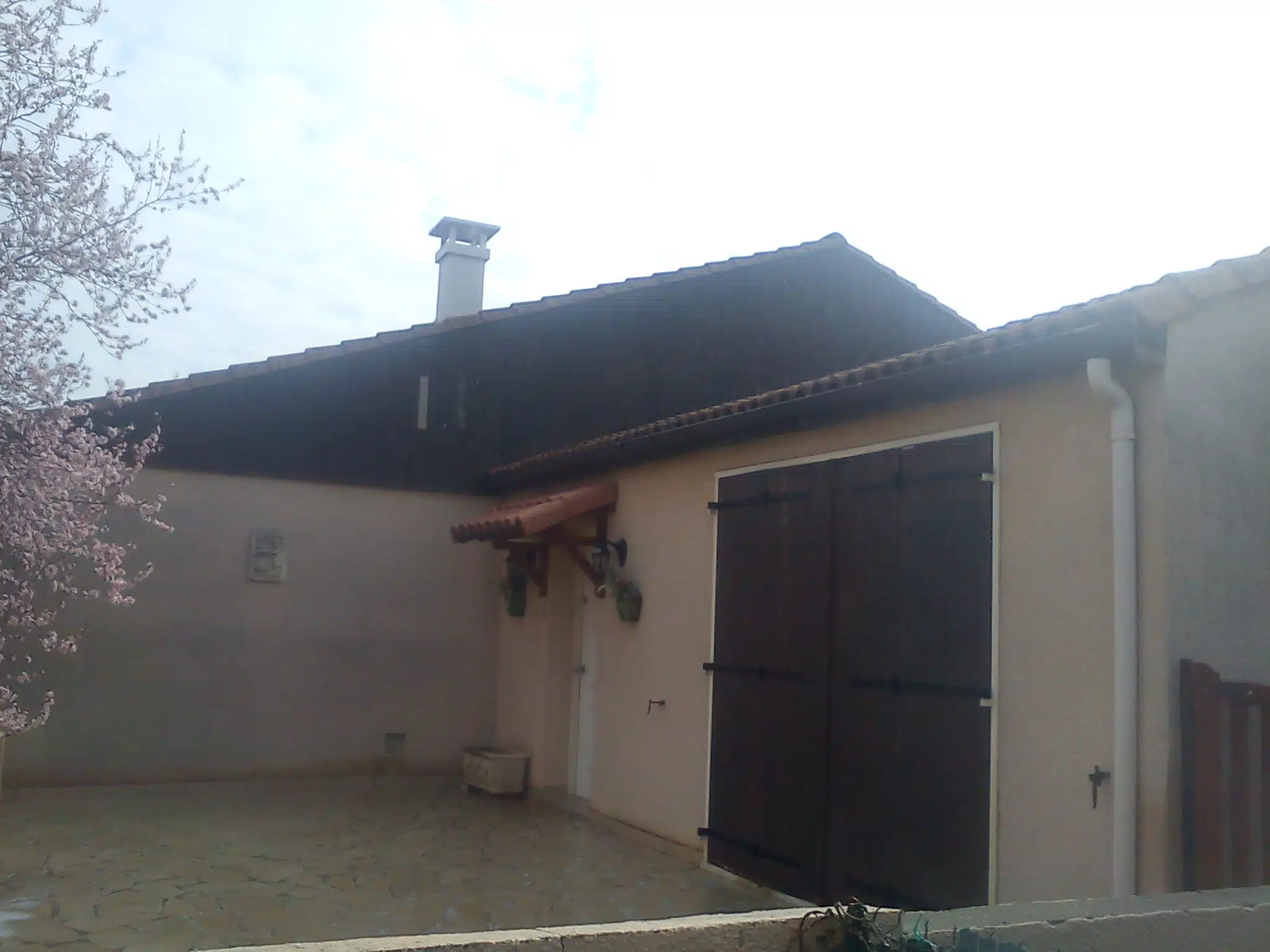Maison basse avec porte de garage sombre après travaux