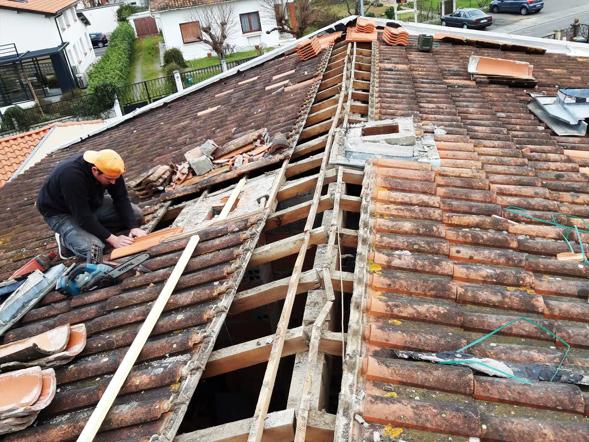 couvreur-tournefeuille-NAVERI Couvreur déposant les tuiles d'une toiture depuis une échelle