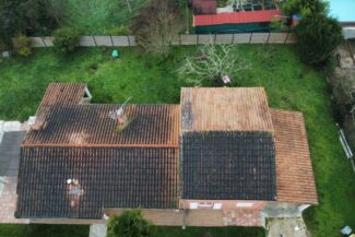 Vue aérienne d'une toiture partiellement démoussée à Tournefeuille