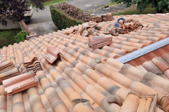 Faîtage en cours de remontage avec tuiles en attente à La Salvetat-Saint-Gilles