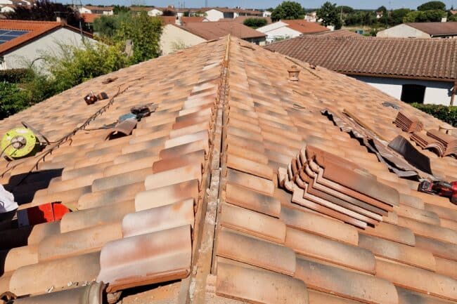 Tuiles canal stockées par paquets sur la toiture pendant le chantier à La Salvetat-Saint-Gilles