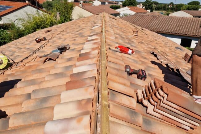 Toiture en cours de réfection avec outils et tuiles en attente à La Salvetat-Saint-Gilles
