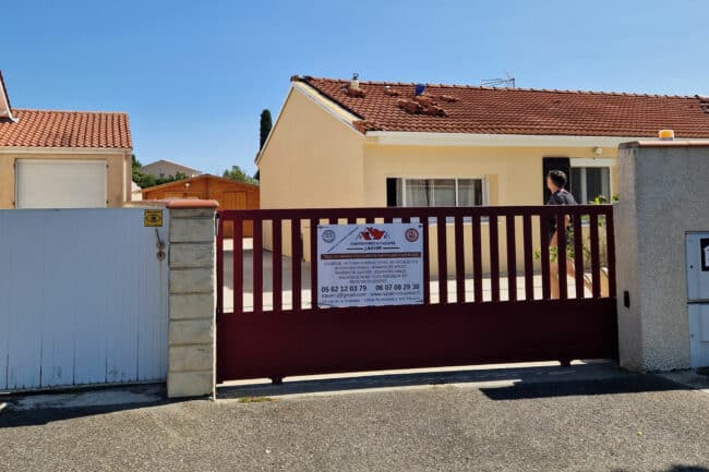 couvreur-toulouse-refection-toiture-J-Naveri Panneau de chantier devant un portail lors d'une réfection à Toulouse