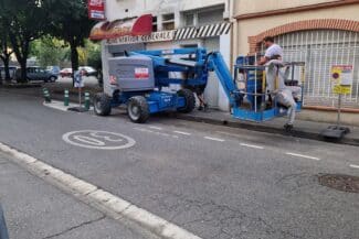 Nacelle et camion de chantier devant l'immeuble en réfection à Toulouse