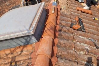 Solin zinc et tuiles reprises le long d'un mur d'immeuble à Toulouse