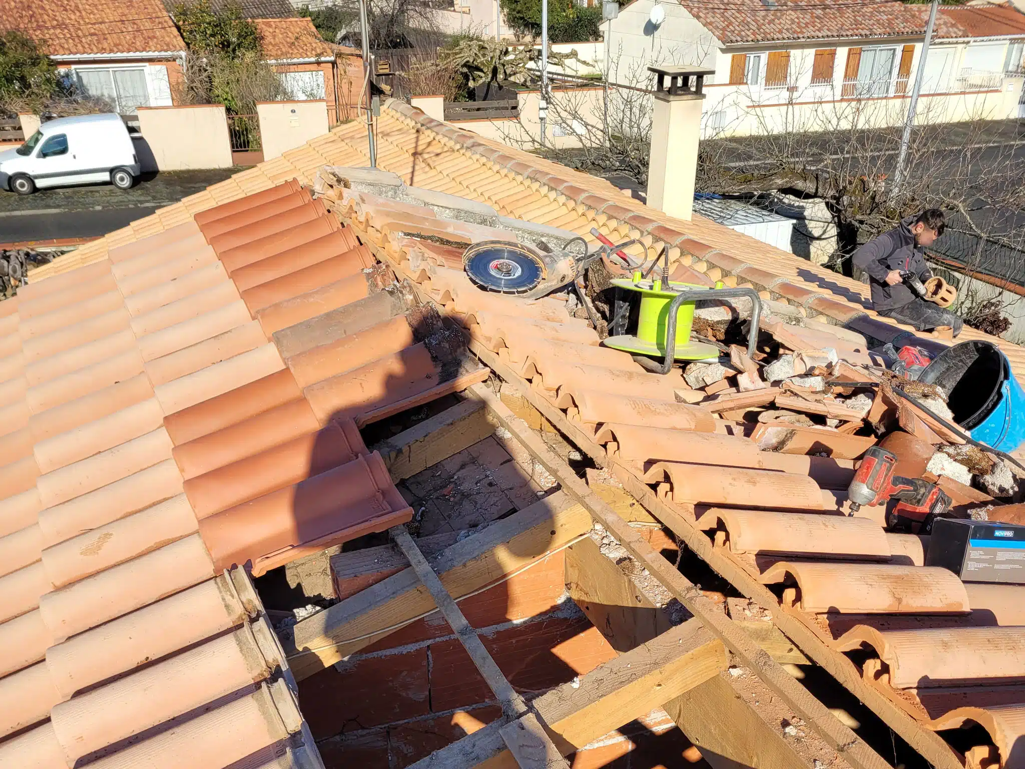 Couvreurs déposant les tuiles d'une toiture à Aspet