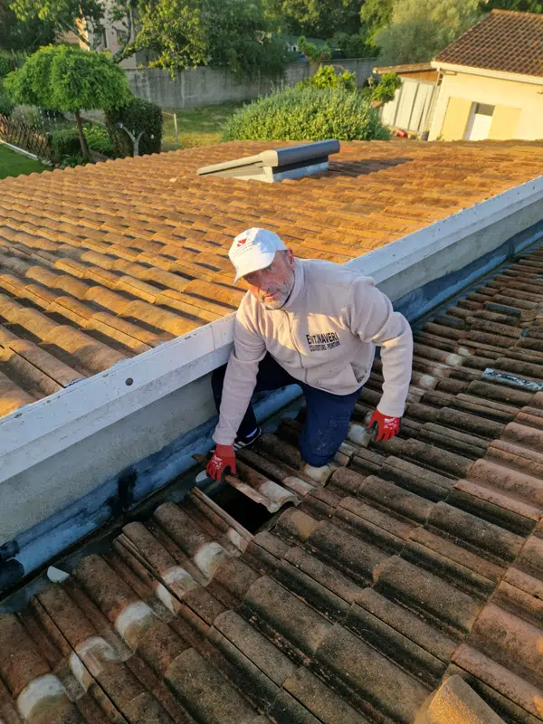 Couvreur travaillant sur une toiture équipée d'un chéneau zinc à Rieumes