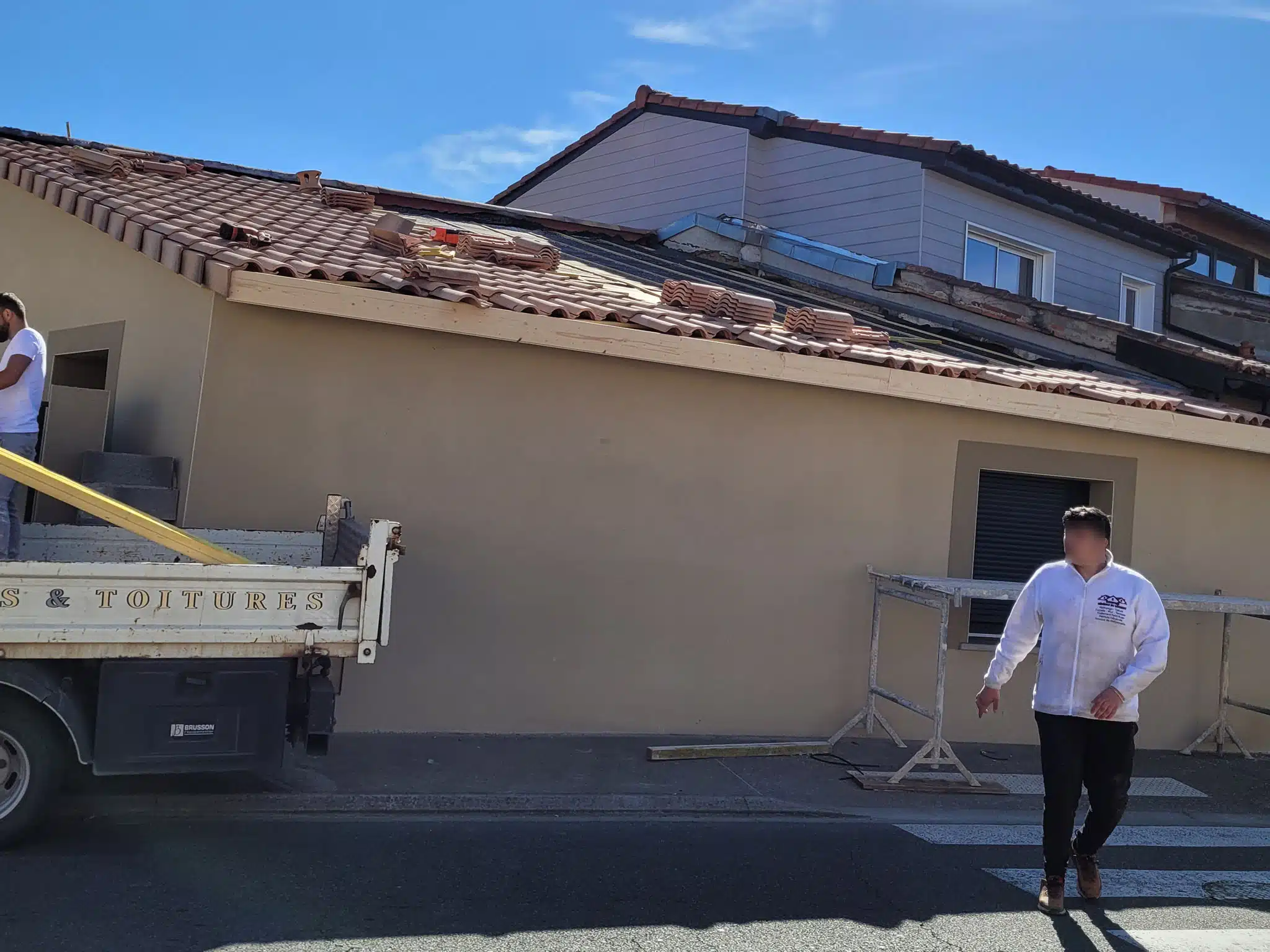 Couvreur devant un bâtiment en cours de rénovation à Samatan