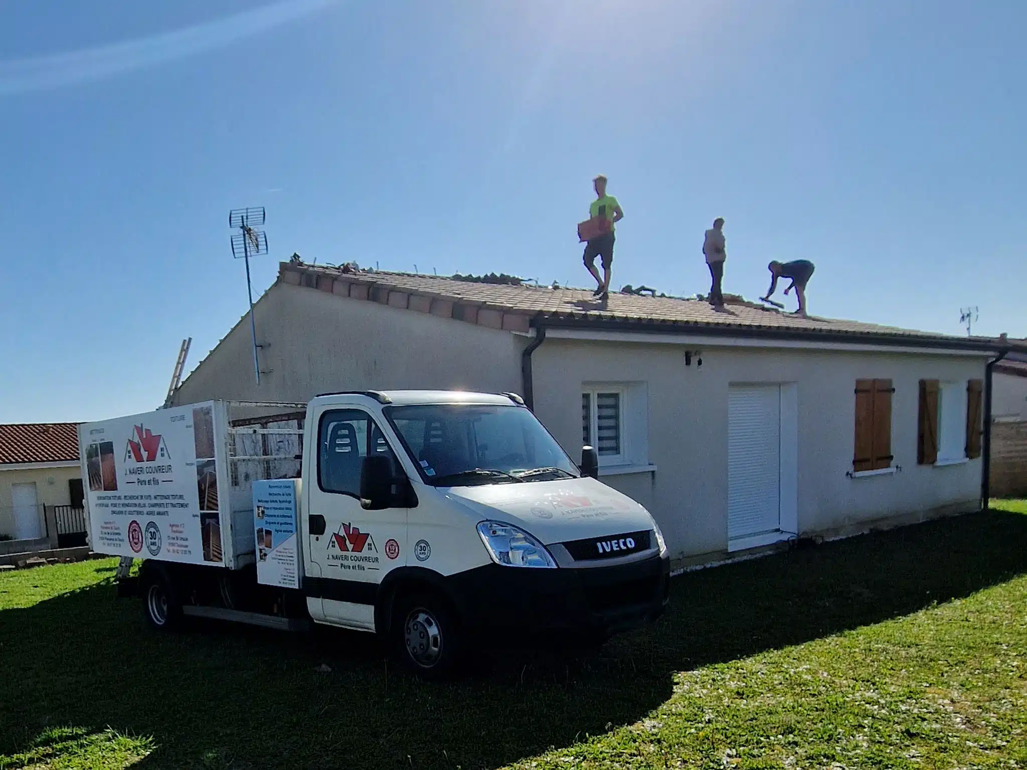Couvreurs au travail sur la toiture d'une maison de plain-pied à Valentine