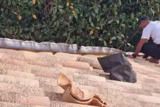 Dépose des tuiles faîtières scellées sur un toit de Grenade