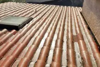 Fenêtre de toit dégagée de la mousse sur une couverture à Pibrac