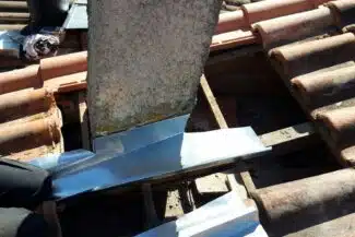 Pièces de zinc façonnées au pied de la souche de cheminée, Salies-du-Salat