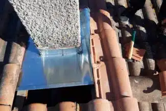 Tuiles canal reposées contre la bavette zinc de la souche, Salies-du-Salat